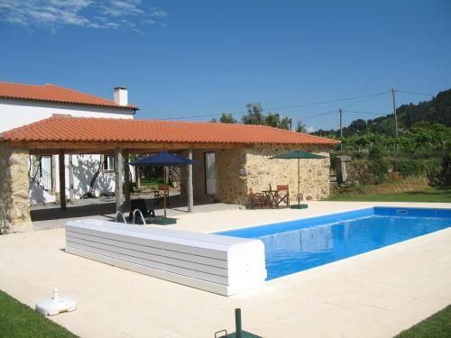 a swimming pool in front of a house at Casa dos castanheiros in Ponte de Lima