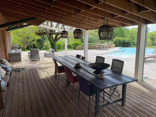 une terrasse en bois avec une table et des chaises en bois dans l'établissement Epicure, à Carignan