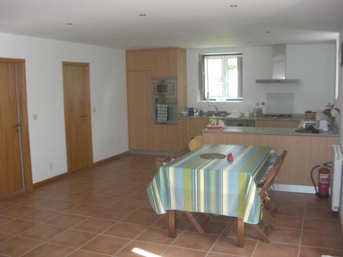 a kitchen with a table with a striped table cloth on it at Casa dos castanheiros in Ponte de Lima