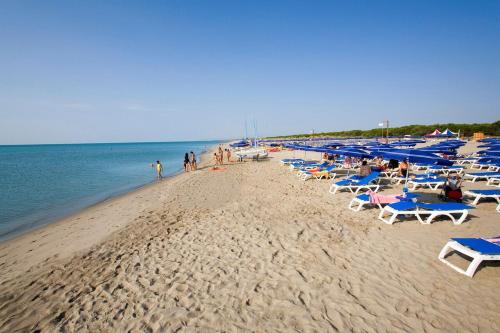 a beach with blue umbrellas and people on it at La veranda del Melograno - Pisticci in Pisticci