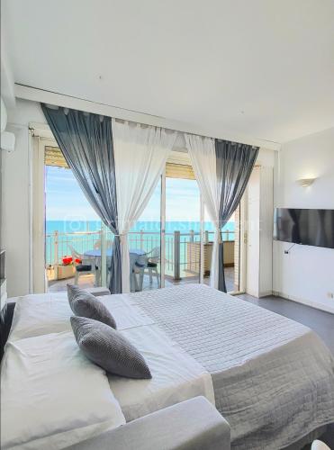 um quarto com uma cama grande e vista para o oceano em Colibrì em Nettuno