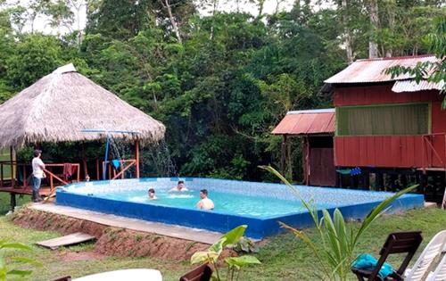 grupa ludzi w basenie w obiekcie Jungle Explorer Lodge w mieście Mazán