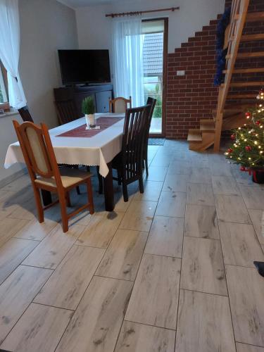 a dining room with a table and chairs and a christmas tree at Domki Agata in Ostrzyce