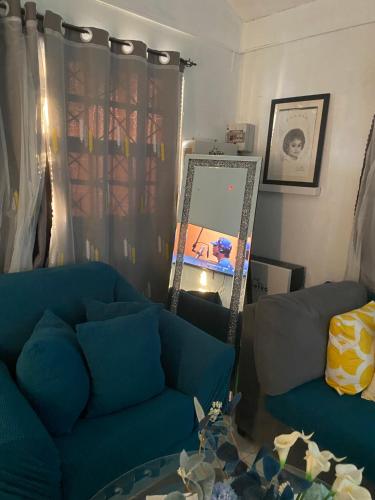 sala de estar con sofá azul y espejo en Beautiful Vacation Home, en Ocho Ríos