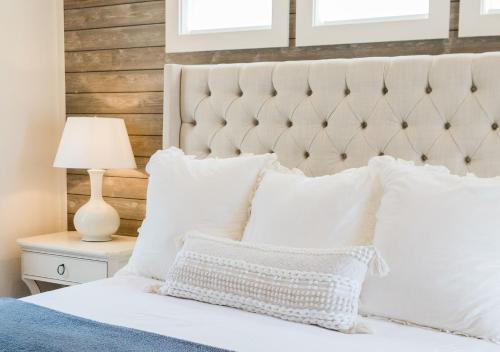 a bedroom with a white bed with white pillows at Kaya Cottages in Dahlonega