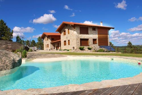 a large swimming pool in front of a house at Retiro do Vouga in Águas Boas