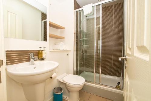 uma casa de banho com um WC, um lavatório e um chuveiro em Blue Harbour Apartments em Edimburgo