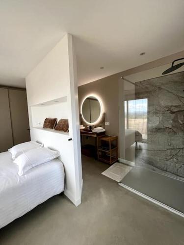 une chambre avec un lit et un miroir dans l'établissement Villa des pins - sud Ardèche 4 lits - 6 pers, à Lablachère