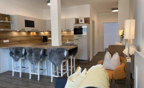 a kitchen and living room with a bar with stools at Villa Rosalie Sassnitz in Sassnitz