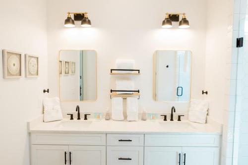 a bathroom with two sinks and two mirrors at Kaya Cottages in Dahlonega