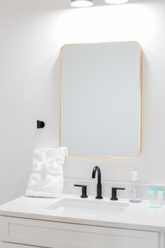 a bathroom sink with a large mirror above it at Kaya Cottages in Dahlonega