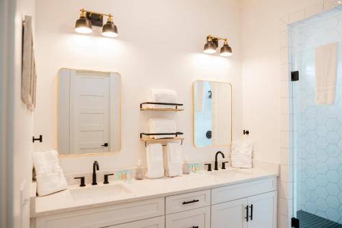 a bathroom with two sinks and two mirrors at Kaya Cottages in Dahlonega
