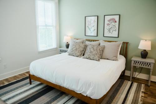 a bedroom with a bed with white sheets and pillows at Kaya Cottages in Dahlonega