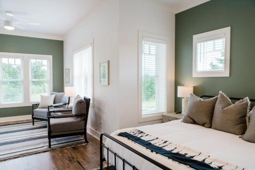 a bedroom with green walls and a bed and a chair at Kaya Cottages in Dahlonega