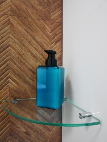 a blue container sitting on a glass shelf at Alda in Pyrzowice