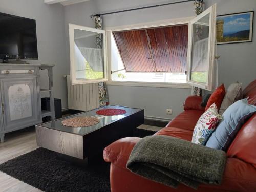 a living room with a red couch and a coffee table at Appartement indépendant privatif avec jardin in Le Crès