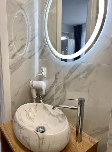 a bathroom with a white sink and a mirror at DOBA RENT Wysockiego 104 in Białystok