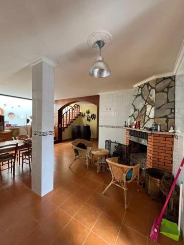 a living room with a fireplace and a table and chairs at Casa de Campo - Vila Boa in Vila Boa