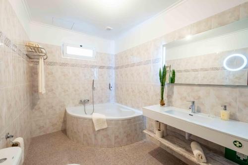 a bathroom with a tub and a sink at Casa do Neves in Funchal