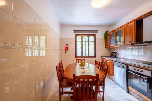 a kitchen with a wooden table and chairs at Casa do Neves in Funchal
