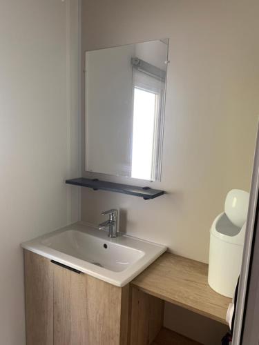 umywalka łazienkowa z lustrem i oknem w obiekcie MH 008 Bora Bora sur emplacement exceptionnel en lisière de forêt dans camping 4 étoiles w mieście Saint-Julien-en-Born