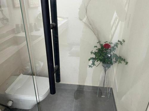 a bathroom with a toilet and a vase with a flower at Le sidi cabins Hacienda Bay in El Alamein