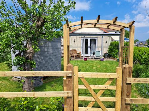 a wooden fence with a gate and a gazebo at Apple Tree Corner Apartment in Yate