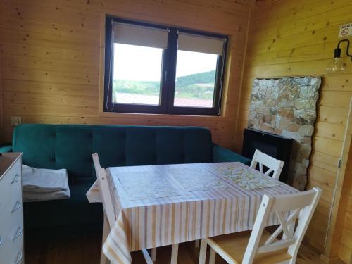 a dining room with a table and chairs and a window at Pod Bercem in Solina