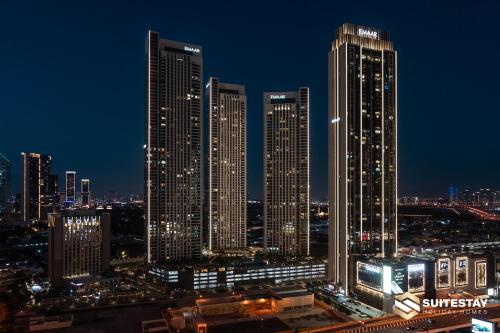 a group of tall buildings in a city at night at Fashion avenue Dubai Mall -The Residence in Dubai