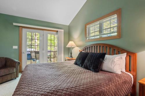 a bedroom with a bed and a chair and a window at 666 Disciples Village Condo in Boyne Falls