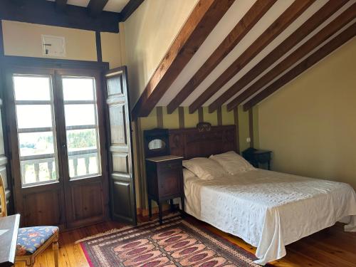 Hotel Palacio La Casona de Cerrazo في Cerrazo: غرفة نوم بسرير في غرفة بسقوف خشبية