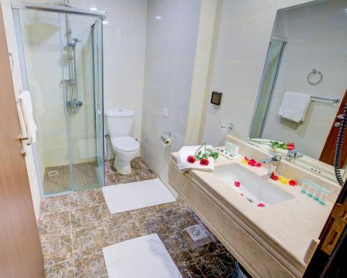 Hayah Diamond Hotel في المدينة المنورة: حمام مع حوض استحمام ودش ومرحاض