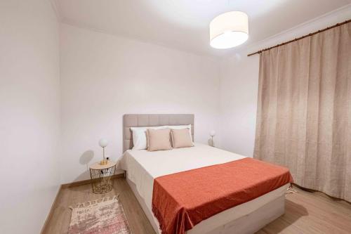 a white bedroom with a bed and a window at Casa do Neves in Funchal