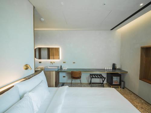 a hotel room with a bed and a table at PAPO'A Harbor Hotel in Kaohsiung