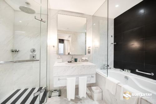 a bathroom with a tub and a sink and a mirror at Fashion avenue Dubai Mall -The Residence in Dubai