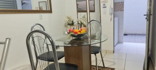 Apartamento encantador 3 في مونتيس كلاروس: طاولة زجاجية مع كراسي وصحن فاكهة عليه