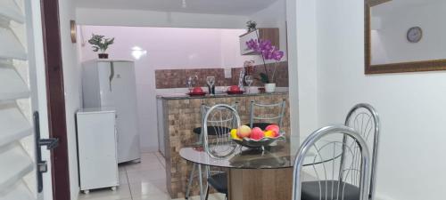 uma cozinha com uma mesa com uma taça de fruta em Apartamento encantador 3 em Montes Claros