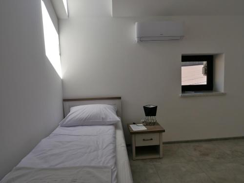 a bedroom with a bed and a nightstand and a window at Alda in Pyrzowice