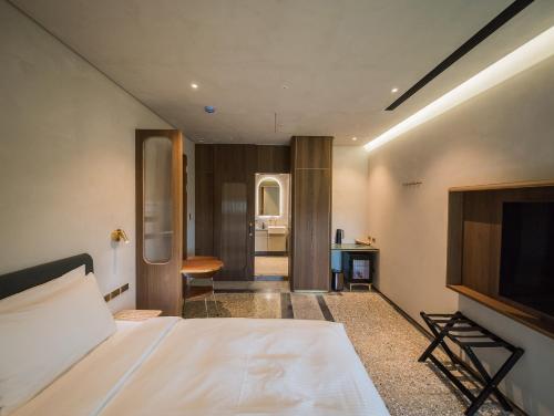 a hotel room with a bed and a television at PAPO'A Harbor Hotel in Kaohsiung