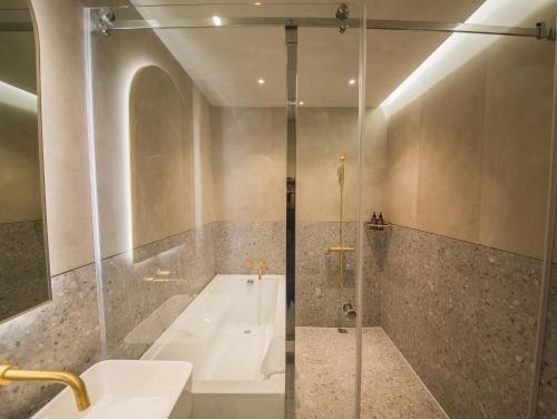a bathroom with a tub and a sink and a shower at PAPO'A Harbor Hotel in Kaohsiung