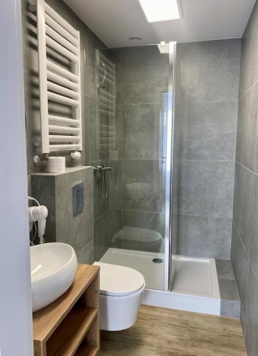 a bathroom with a shower and a toilet and a sink at DOBA RENT Wysockiego 104 in Białystok