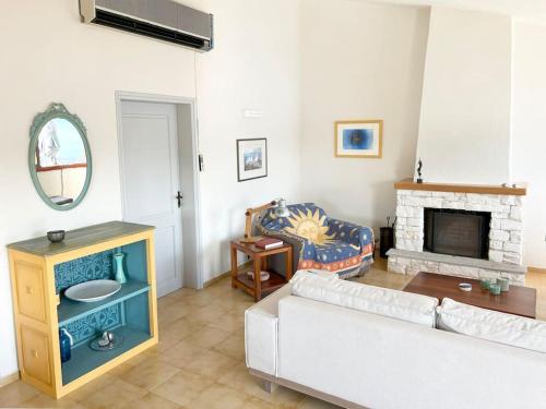 a living room with a couch and a fireplace at Κατοικία με ιδιωτική παραλία in Khorió Akhíllion