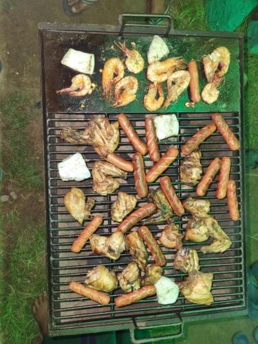a grill with chicken and vegetables on it at Nilaveli Guest House in Nilaveli