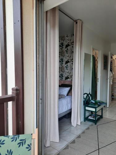 a bedroom with a bed and a mirror in a room at Horizon Marin accès direct plage in Cabourg