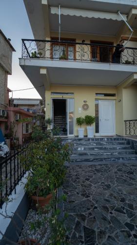 a building with a balcony and a person sitting on the balcony at Studios Vaso - Center in Parga