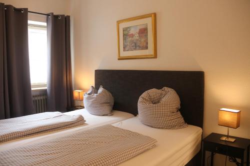 a bedroom with two beds with pillows and a window at Landgasthof Doldewirt in Bernbeuren