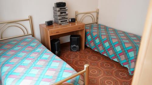Habitación con 2 camas individuales y escritorio. en Casa vacanze San Cassiano Salento, en San Cassiano