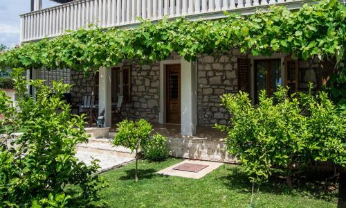 a stone house with a bunch of trees in front of it at Apartment Derossi in Umag