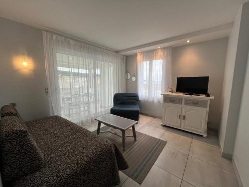 a bedroom with a bed and a tv and a chair at H&ocirc;tel Valencia in Hendaye