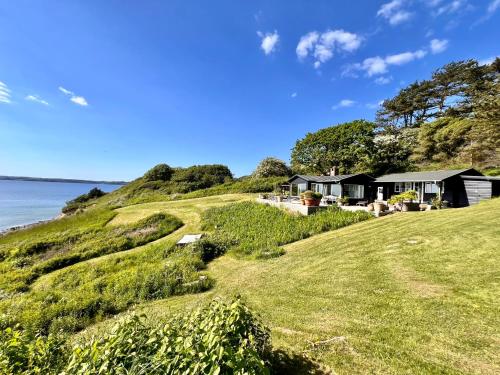 a house on a hill next to the ocean at Denmark's Most Charming Beach Cottage in Kalundborg